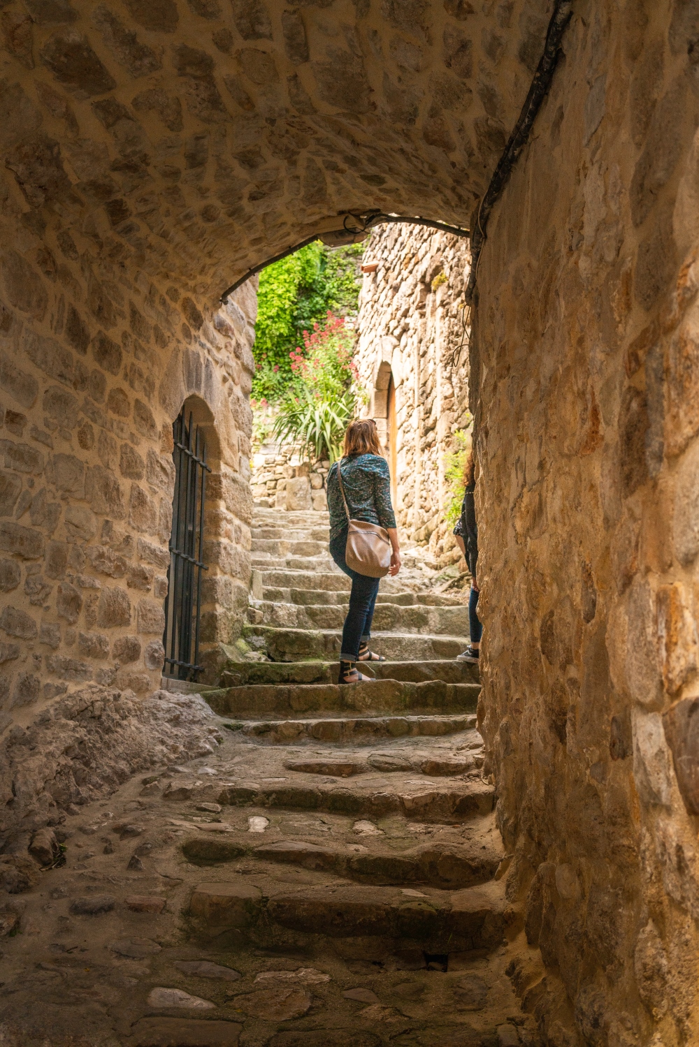 femme visitant un village de caractère en Ardèche du sud, le village de Banne, vieilles pierres et escaliers typiques, prise par Borre Zimmermann